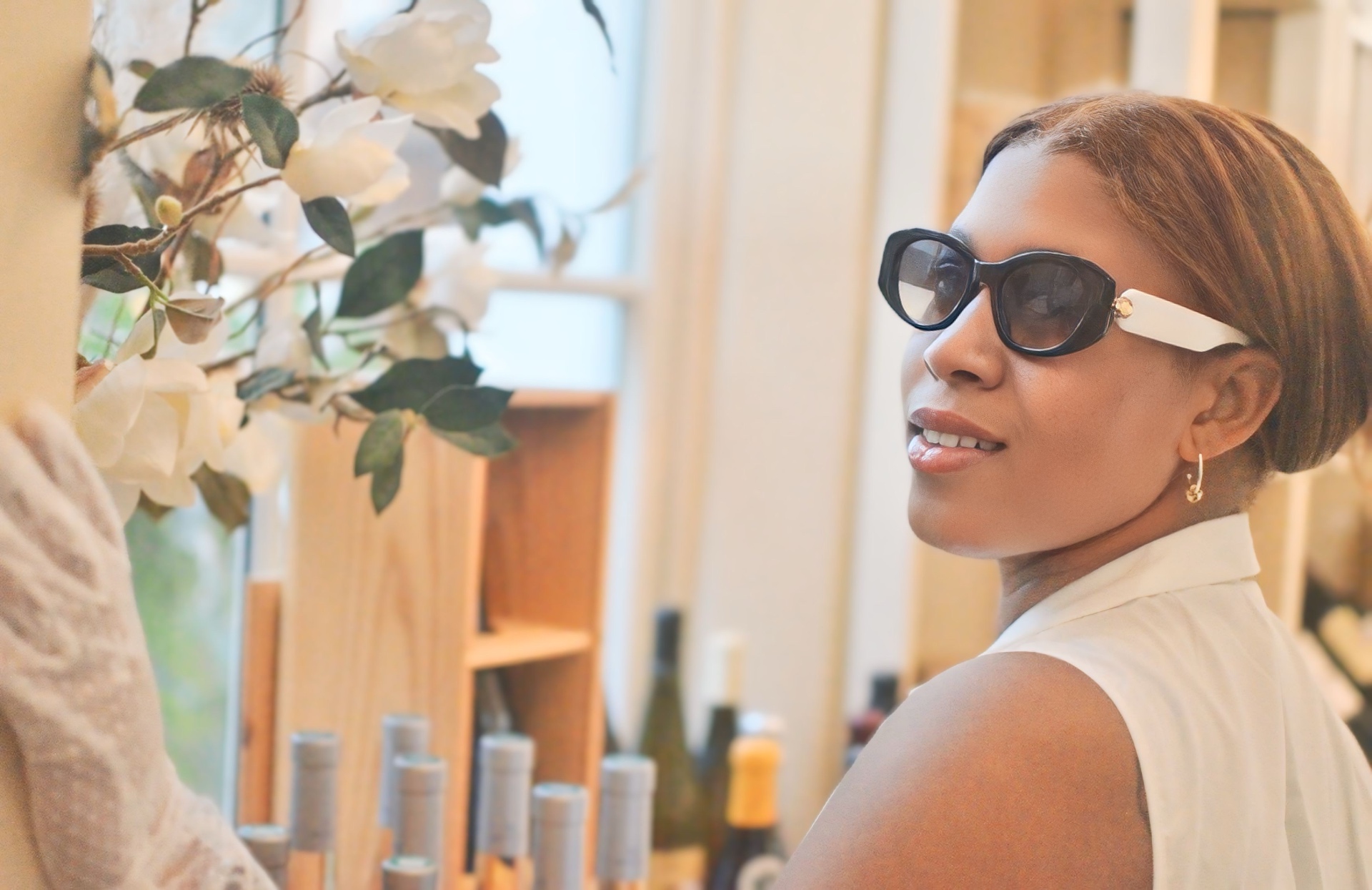 Toni wearing sunglasses beside flowers